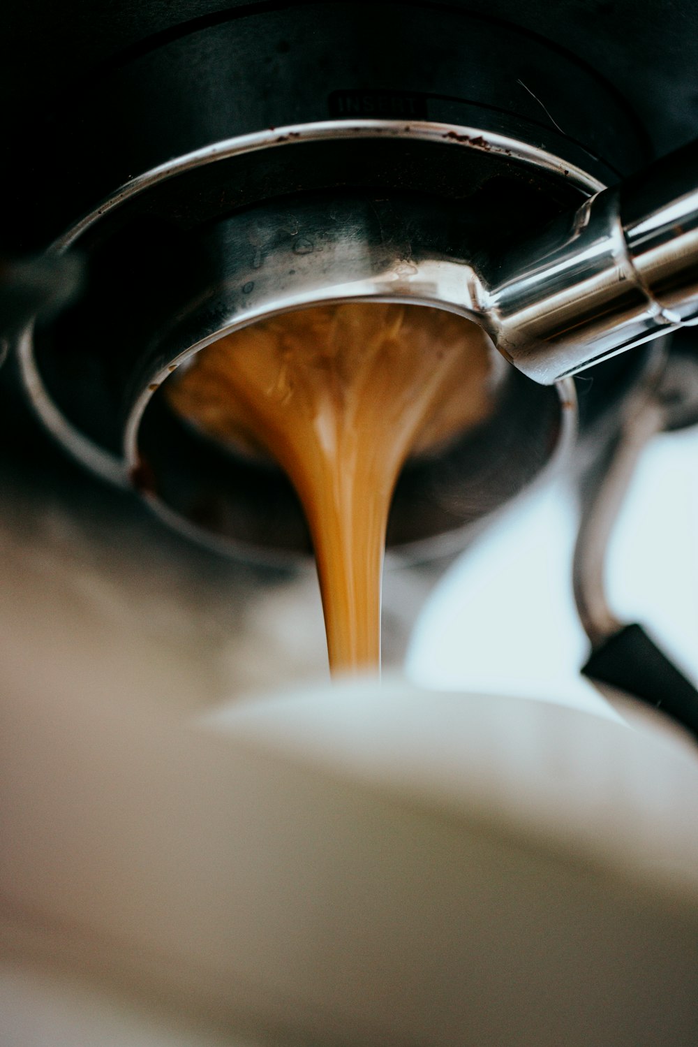 Espresso läuft aus einem Siebträger in eine Tasse